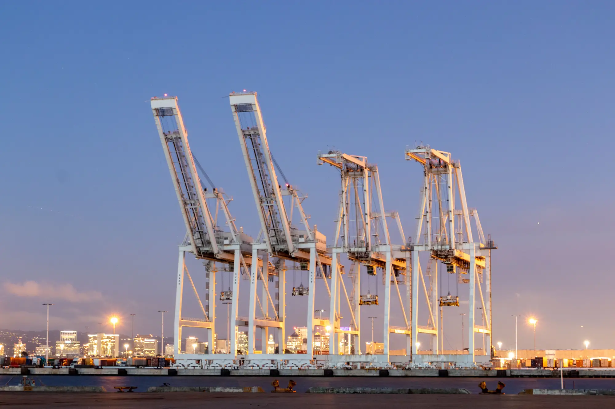 Ship-to-shore cranes along a container terminal quay at dusk